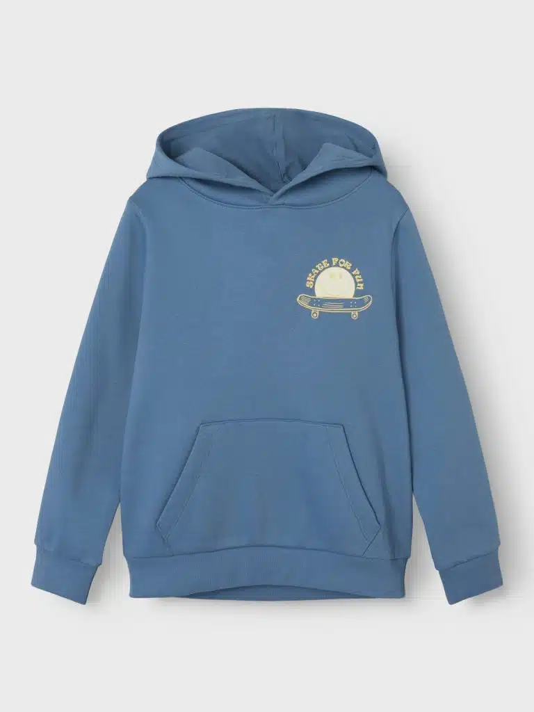 Sweat à capuche bleu coronet à manches courtes , porté par un jeune garçon dans un cadre scolaire. Le style décontracté et confortable du vêtement est mis en valeur, idéal pour la rentrée et les journées d'automne.